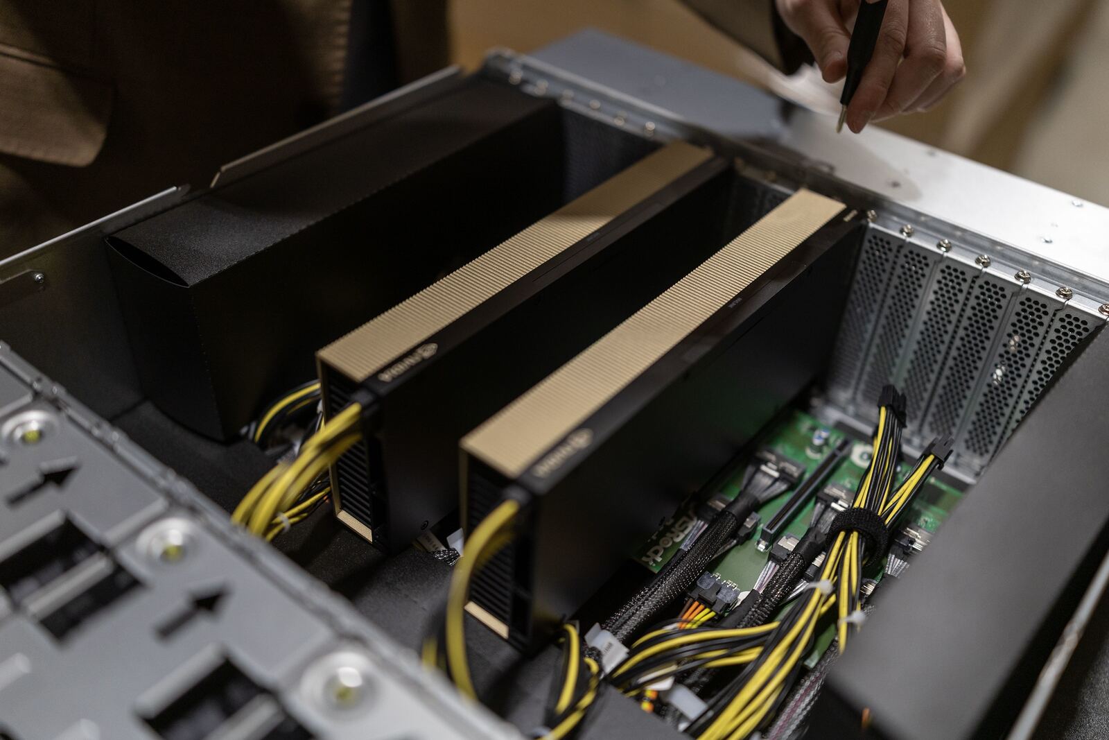 An opened rack-mount GPU node showing accelerator cards, cold plates and the power loom.